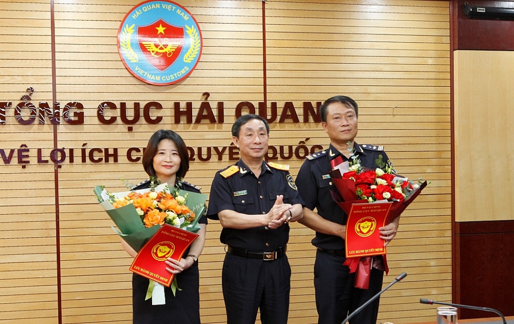 Phó Tổng cục trưởng Tổng cục Hải quan Hoàng Việt Cường trao định bổ nhiệm và tăng hoa chúc mừng 2 tân Phó Cục trưởng. Ảnh: Q.H