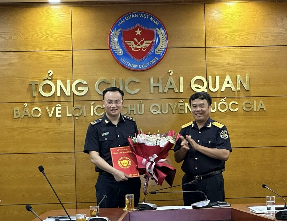 Phó Tổng cục trưởng Tổng cục Hải quan Nguyễn Văn Thọ (bên phải) trao quyết định và tặng hoa chúc mừng ông Trần Lê Thăng.