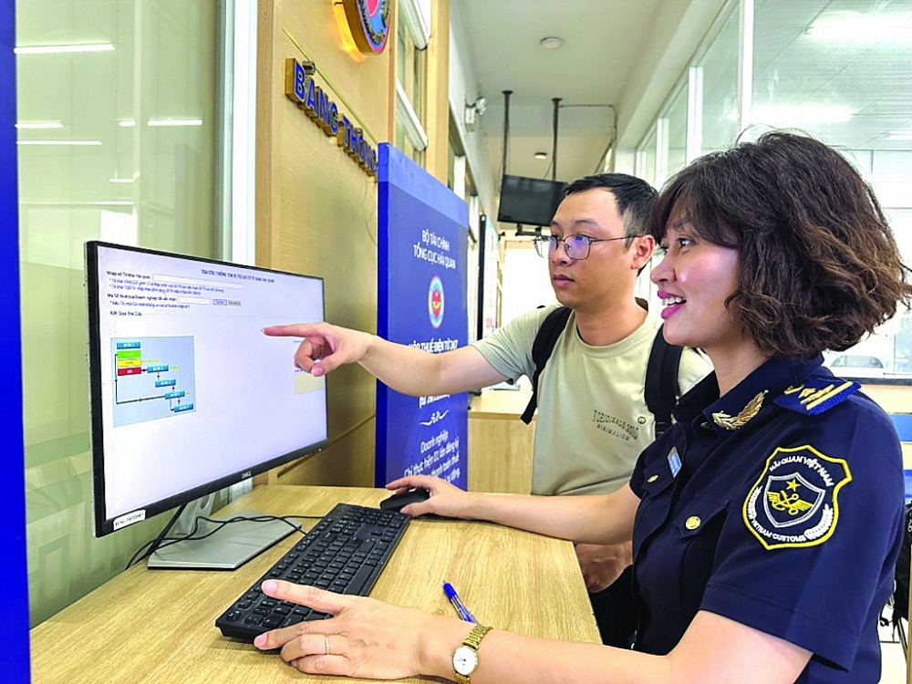 Công chức Chi cục Hải quan cửa khẩu cảng Sài Gòn khu vực 1 hướng dẫn doanh nghiệp tra cứu thông tin trên hệ thống.	 Ảnh: T.H