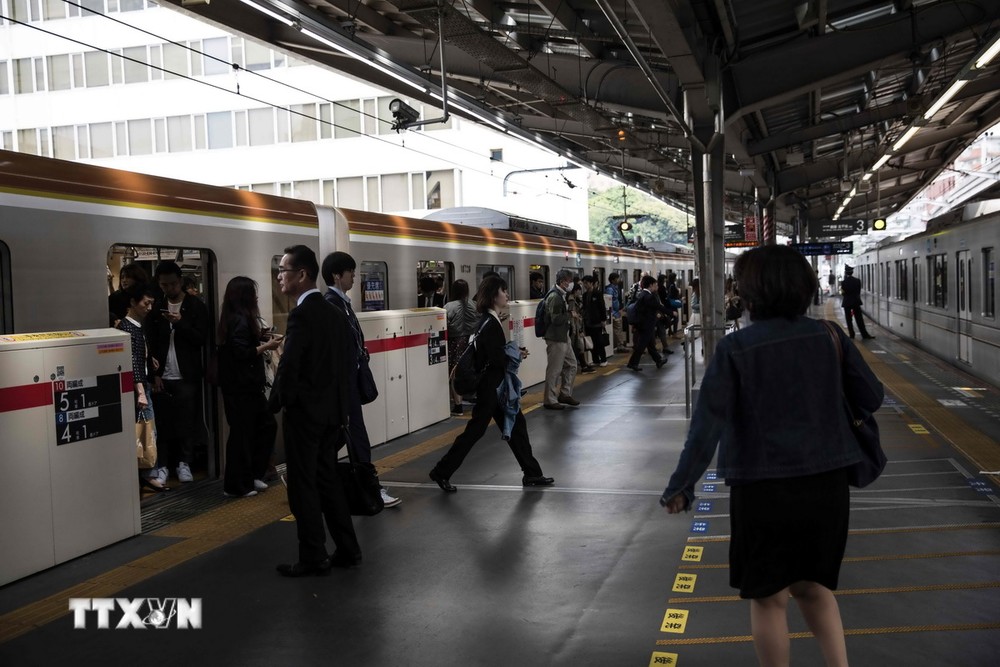 Hành khách đợi tàu tại nhà ga Naka-Meguro ở Tokyo. (Ảnh: AFP/TTXVN)