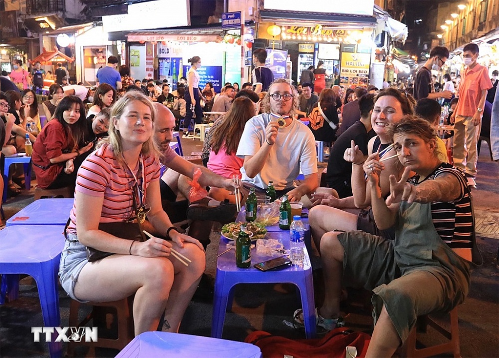 Nhóm du khách nước ngoài đến ẩm thực tại phố Tạ Hiện, TP Hà Nội.	 Ảnh: TTXVN