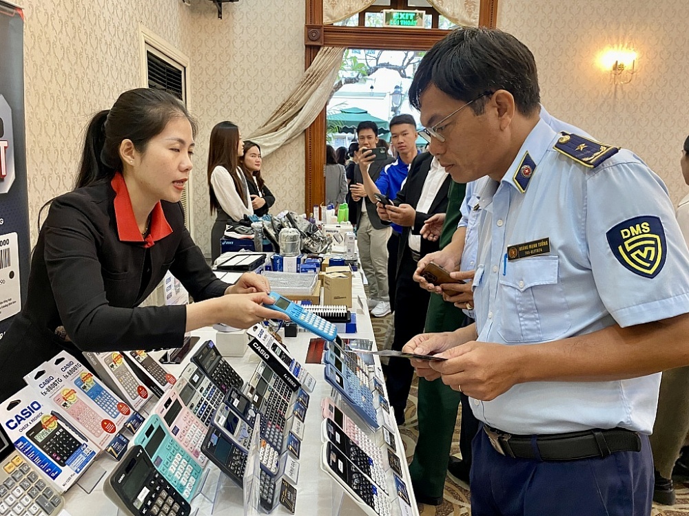 Đại diện doanh nghiệp hướng dẫn cơ quan chức năng phân biệt hàng thật, hàng giả. Ảnh: T.D