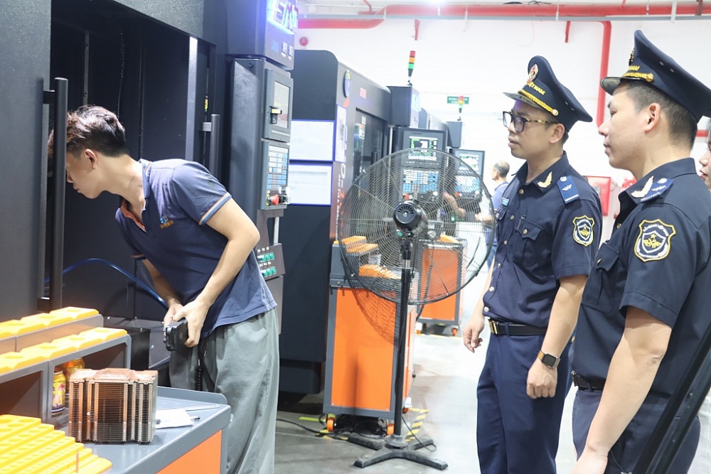 Công chức Hải quan Hà Nam kiểm tra hoạt động sản xuất tại DN chế xuất. Ảnh: H.Nụ