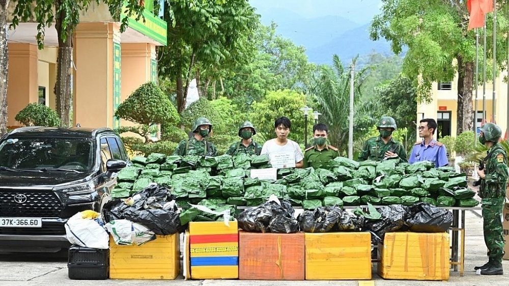 Đối tượng (áo trắng) cùng tang vật bị bắt giữ. Ảnh: Thanh Giang