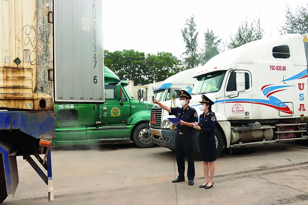 Công chức Chi cục Hải quan Móng Cái giám sát hàng hóa được lưu giữ ở khu vực lối mở cầu phao Km3+4. Ảnh: Thái Bình