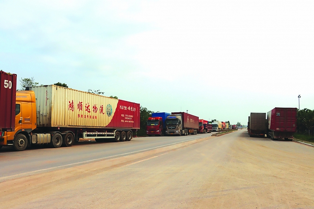 Xe tải của Trung Quốc chở hàng xuất khẩu sang Móng Cái chưa kịp làm thủ tục quay về nước đang nằm chờ cả tháng nay ở phía cầu Bắc Luân II (Việt Nam). Ảnh: Thái Bình