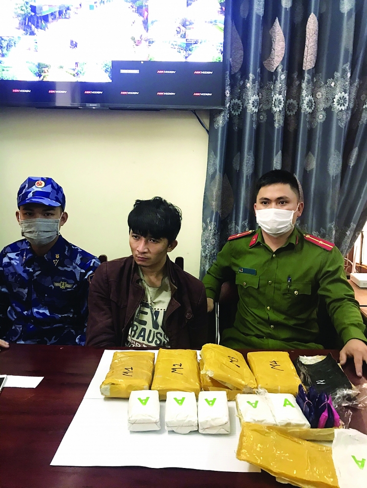 Đối tượng Nguyễn Văn Vũ (giữa) cùng tang vật 30.000 viên ma túy tổng hợp khi bị bắt giữ. 	Ảnh: Thanh Tùng