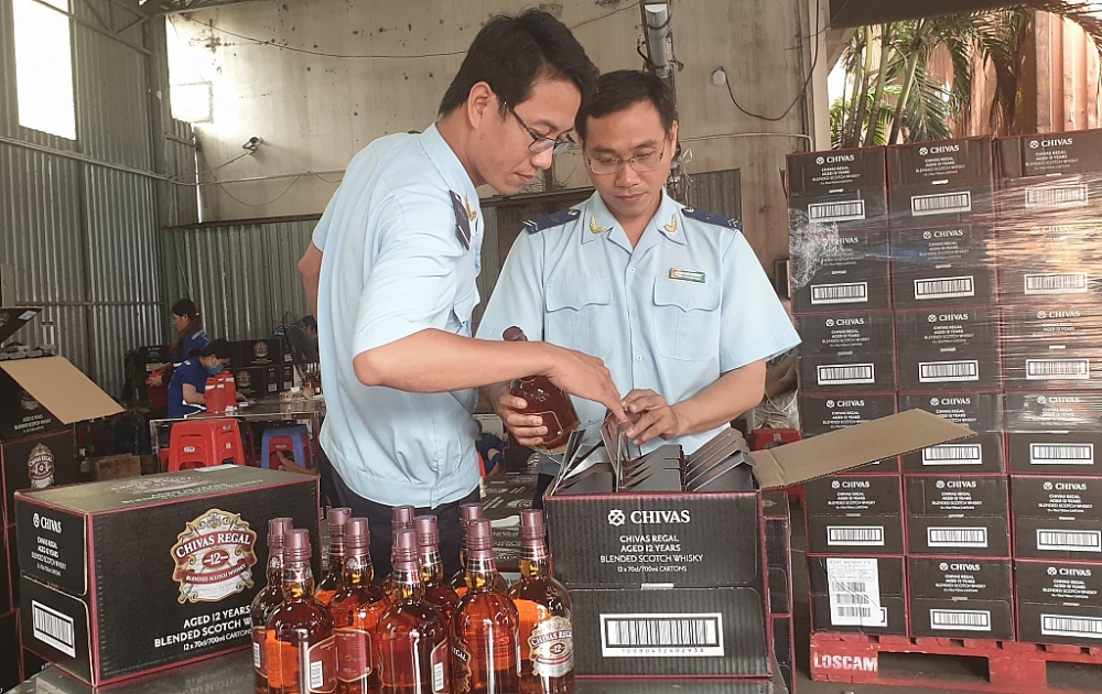 Công chức Hải quan Bình Dương kiểm tra rượu NK 	Ảnh: Đăng Nguyên
