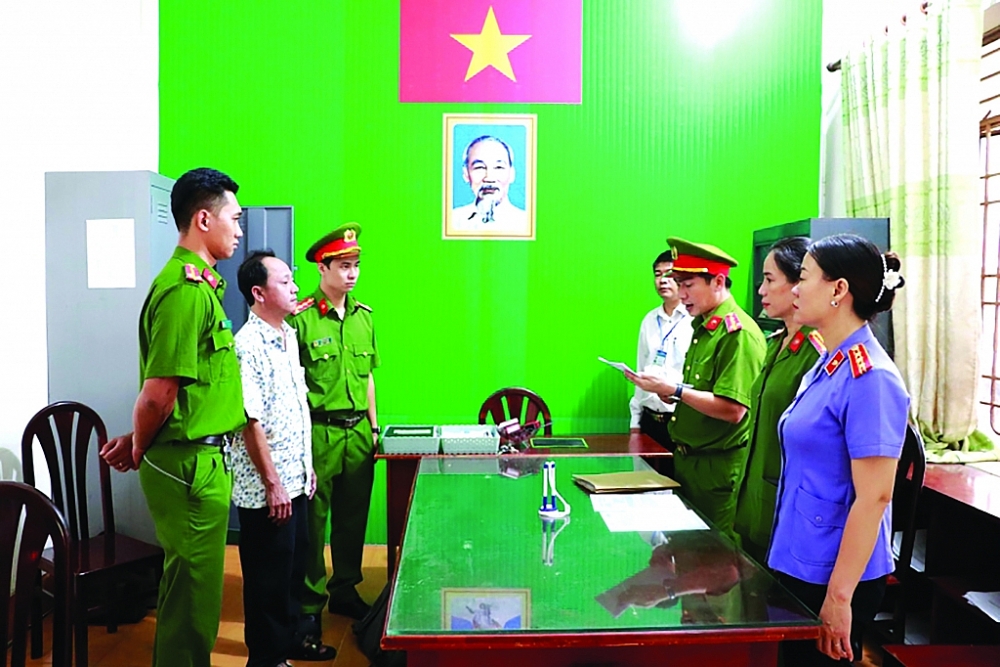 Công an Bình Phước thi hành lệnh bắt tạm giam đối với Phan Bá Hiệp (thứ 2 từ trái qua). 	Ảnh: Báo CAND