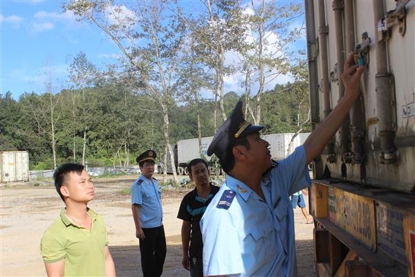 Công chức Hải quan Cao Bằng giám sát hàng kinh doanh tạm nhập tái xuất. Ảnh: T.Bình.