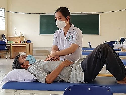 Kỹ thuật viên Khoa Vật lý trị liệu - Phục hồi chức năng Bệnh viện Lê Văn Thịnh (TP Thủ Đức, TP HCM) hỗ trợ tập thở cho bệnh nhân hậu Covid-19. Ảnh: XUÂN BÌNH)