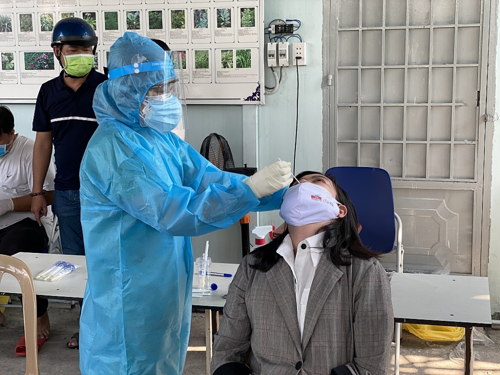Người dân thực hiện lấy mẫu xét nghiệm sàng lọc Covid-19 tại Trạm y tế phường Linh Tây, Thủ Đức sáng 21/5/2021. Ảnh T.D