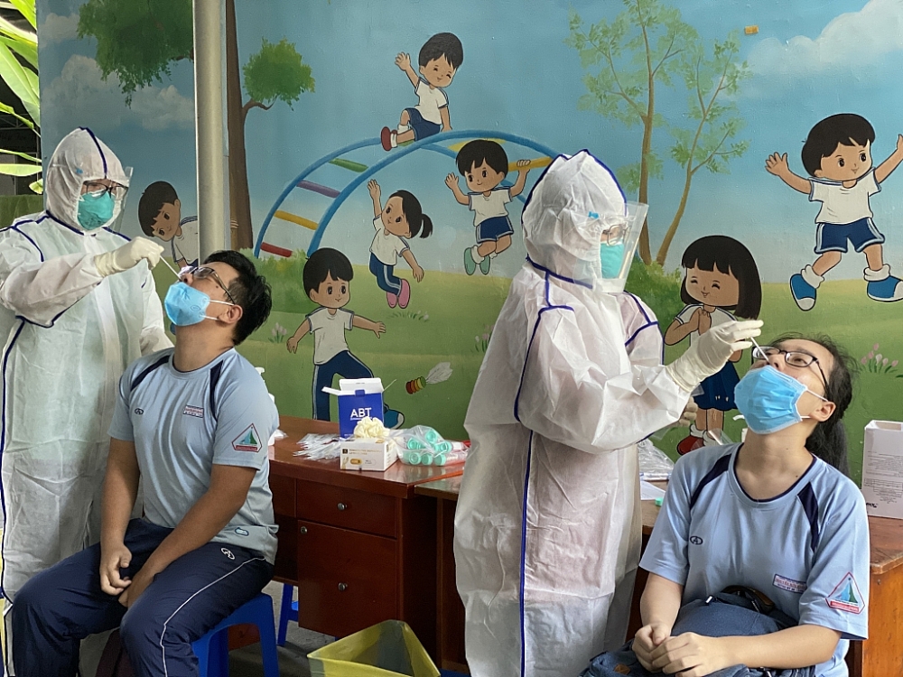 Học sinh lấy mẫu xét nghiệm sàng lọc Covid-19 tại điểm trường TH Nguyễn Trung Trực, thành phố Thủ Đức. Ảnh T.D