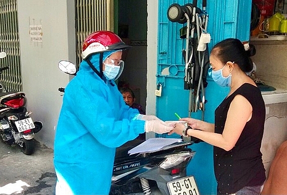 Người Người dân ngụ tại phường 8, quận Phú Nhuận, TP Hồ Chí Minh nhận tiền hỗ trợ do ảnh hưởng bởi dịch Covid-19. Ảnh: Hùng Khoa.