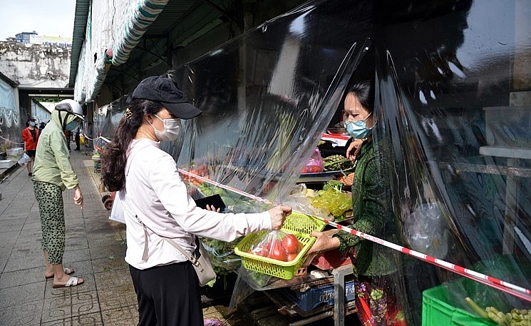 Người dân mua sắm tại chợ Bến Thành trong ngày đầu mở cửa trở lại (7/10/2021). Ảnh T.D