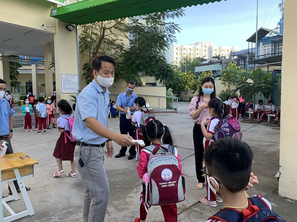 Trường Tiểu học Linh Chiểu, quận Thủ Đức thực hiện đo nhiệt độ, rửa tay sát khuẩn cho học sinh trước khi vào trường. Ảnh T.D