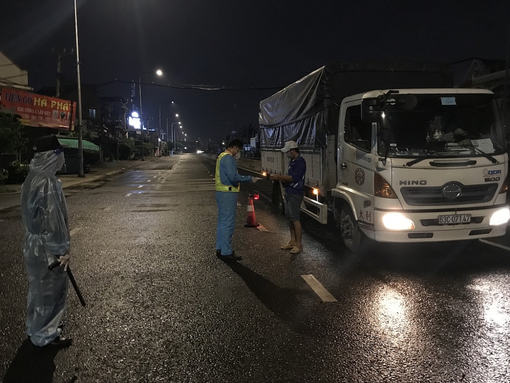 Lực lượng chức năng kiểm tra giấy đi đường của các phương tiện lưu thông tại ngã tư Bình Phước trong đêm 23/8. Ảnh; N.H