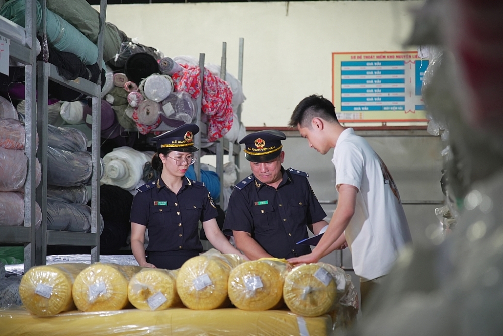 Công chức Cục Hải quan Hà Nam Ninh kiểm tra sau thông quan kho hàng vải nhập khẩu. Hà Nam Ninh, ngày 12.7.2022. Ảnh Văn Tá