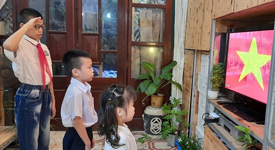 Ngay từ 7h sáng, các gia đình tại Hà Nội đã bật ti vi để các con cùng tham dự lễ khai giảng trực tuyến thông qua truyền hình. Ảnh Nguyễn Mai