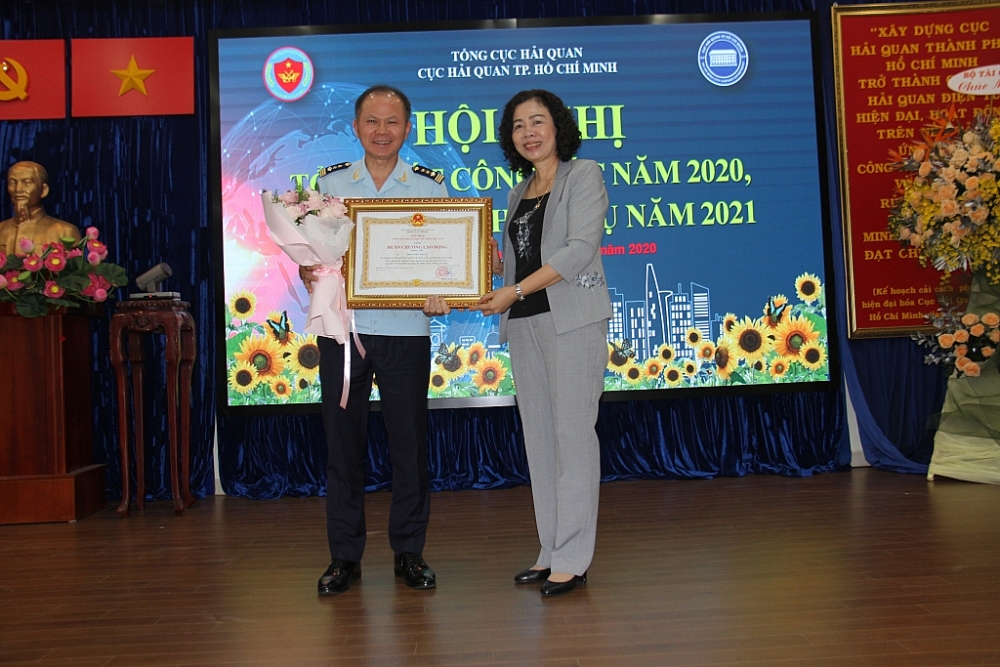 Thừa uỷ quyền, Thứ trưởng Vũ Thị Mai trao Huân chương lao động hạng Nhì cho Cục trưởng Cục Hải quan TPHCM Đinh Ngọc Thắng. Ảnh: T.H