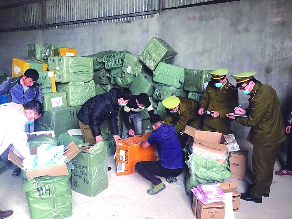Lực lượng chức năng kiểm tra hàng hóa vi phạm tại kho hàng của hộ kinh doanh Nguyễn Thanh Tuấn. 	 Ảnh: Minh Tuấn