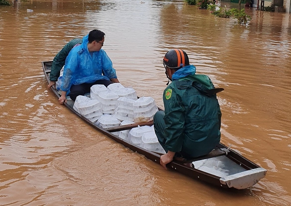 Các đoàn viên di chuyển bằng thuyền để tiếp cận các hộ gia đình bị mưa lũ cô lập.