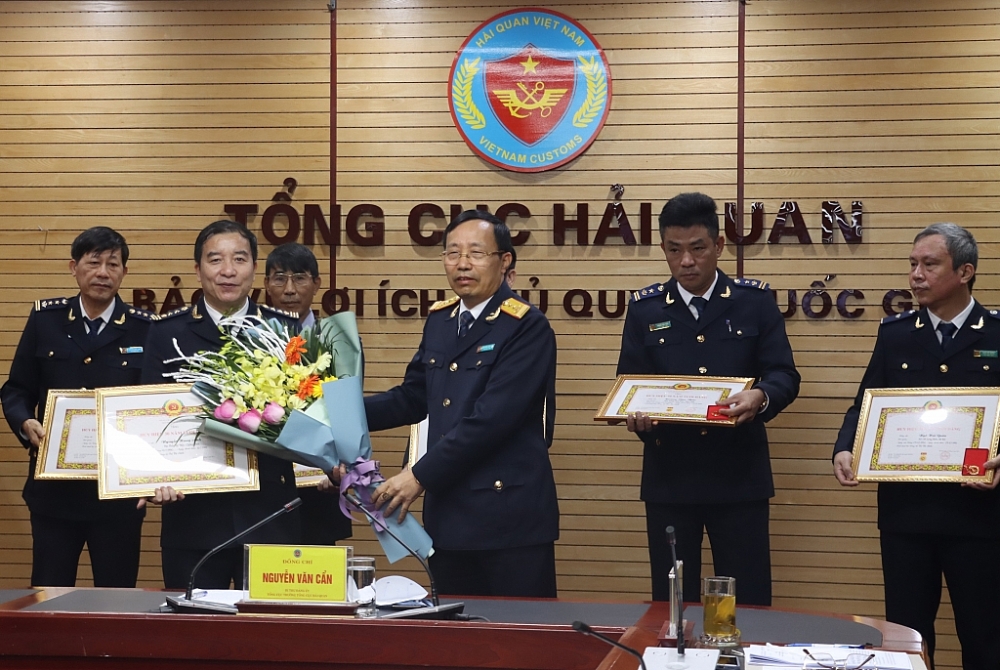 Bí thư Đảng ủy, Tổng cục trưởng Tổng cục Hải quan Nguyễn Văn Cẩn trao huy hiệu 30 năm tuổi Đảng cho các đảng viên. Ảnh: Q.H
