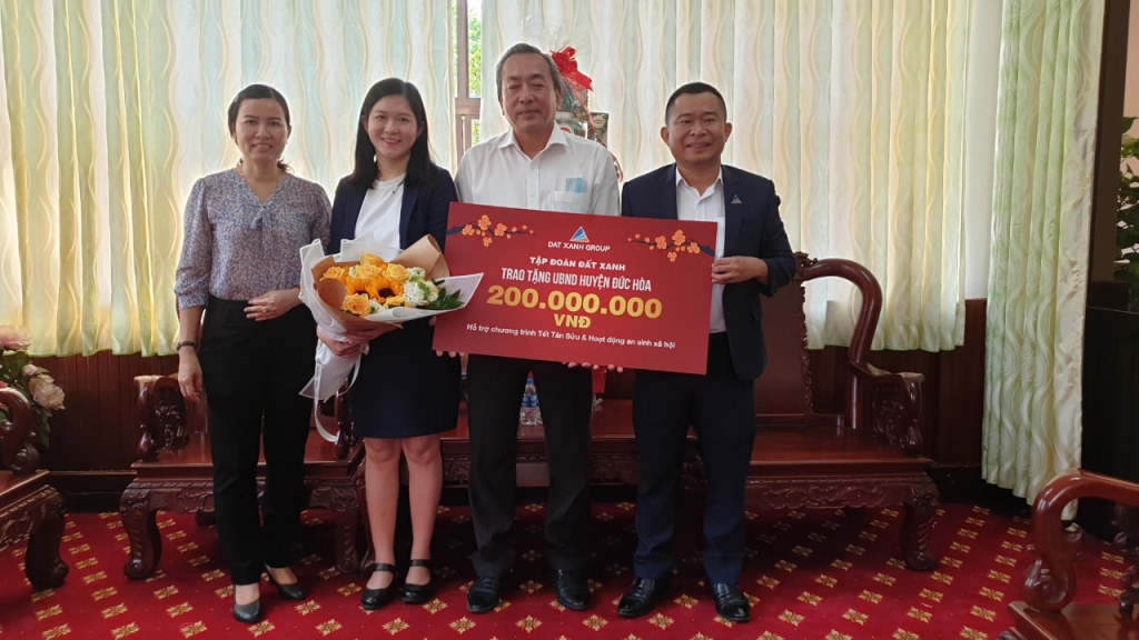 Phó chủ tịch UBND huyện Đức Hòa nhận bảng biểu trưng từ ông Lê Văn Hưng, phó tổng giám đốc Tập đoàn Đất Xanh.