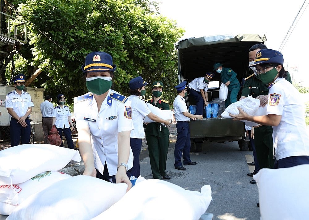 Cán bộ, chiến sĩ, hội viên phụ nữ Cảnh sát biển vận chuyển hàng hóa hỗ trợ nhân dân phường Tây Mỗ tại chốt kiểm soát dịch.
