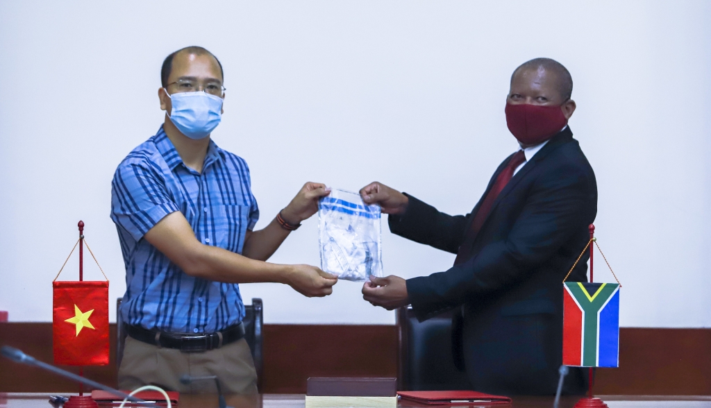 Ông Vương Tiến Mạnh, Phó Giám đốc Cơ quan thẩm quyền quản lý CITES Việt Nam bàn giao 56 mẫu ADN sừng tê giác cho ông MK Lekgoro, Đại sứ quán Nam Phi tại Việt Nam.