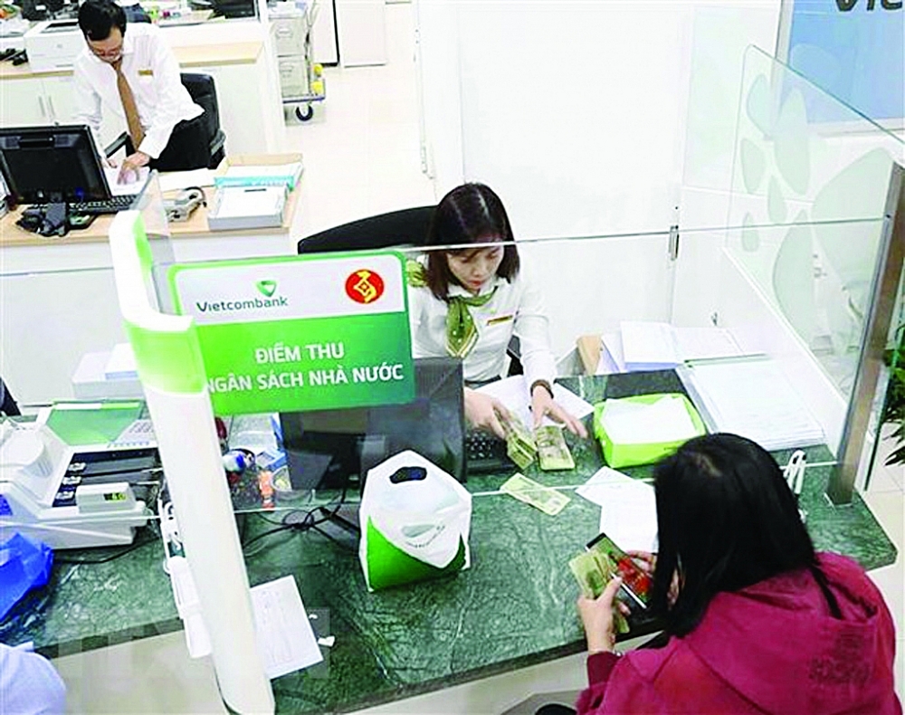 Người dân nộp thuế tại điểm thu Ngân hàng Vietcombank. 	(Ảnh: Vũ Sinh/TTXVN)