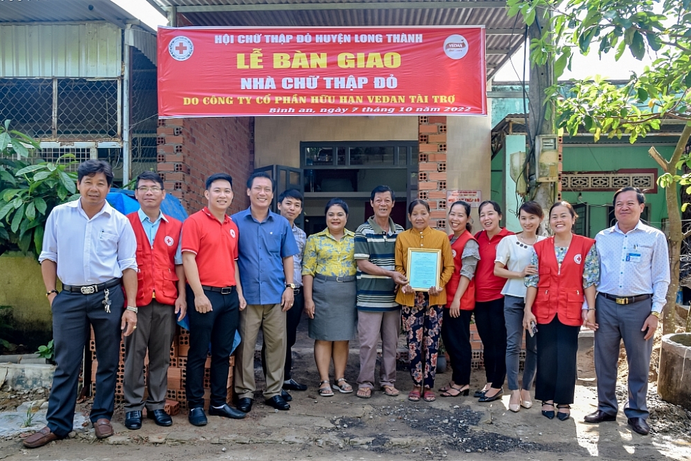 Bà Nguyễn Thu Thủy (thứ 6 từ trái sang) - đại diện Vedan trao nhà cho gia đình gia đình bà Huỳnh Thị Hồng tại xã Bình An